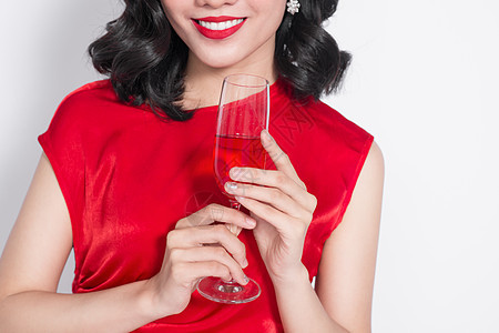 剪裁的美丽亚洲女孩穿着晚礼服 微笑着拿着香槟杯子的画面 年轻的图片