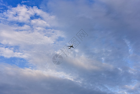 客机在远方飞行 与蓝色的夏天和阴云的天空相相对高清图片