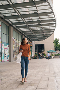 带着购物袋在街上行走的亚洲年轻快乐女人图片