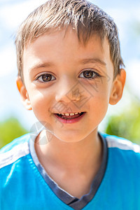 贴近一个微笑的男孩对日晒的肖像图片