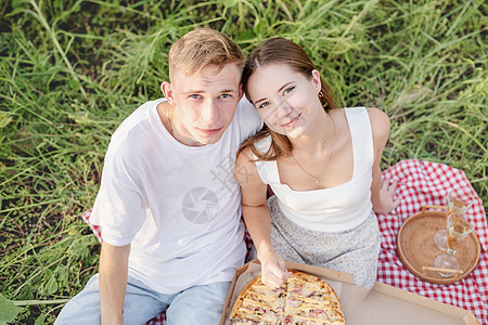 日落时在向日葵田野野餐的年轻夫妇 衬衫 食物图片