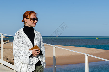 在寒冷的一天 在海滩上的年轻女人图片