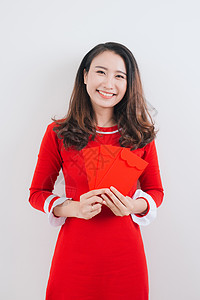 越南妇女传统艺术节服装Ao Dai 持有红钱袋图片