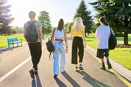 一群青少年朋友在阳光明媚的夏日一起走在路上 背视 学生图片