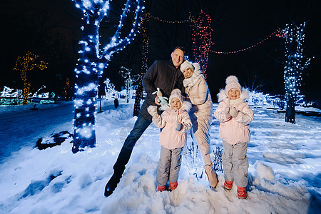 一个大家庭 晚上在圣诞节城市带孩子 夜间有夜光的夜晚 惊喜 天图片