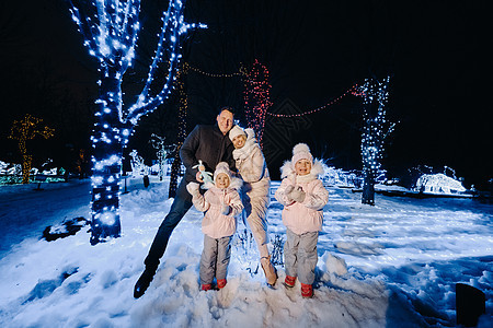 一个大家庭 晚上在圣诞节城市带孩子 夜间有夜光的夜晚 父母 母亲图片