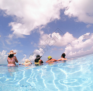 在加勒比海洋的旅馆无限游泳池中玩得开心的年轻女青年 假期概念和单身女子游泳池派对图片