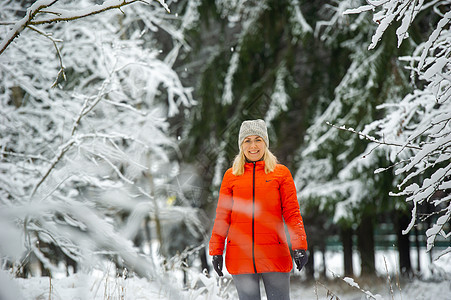 一个穿红色夹克的姑娘 在冬天穿过雪雨林 成人图片