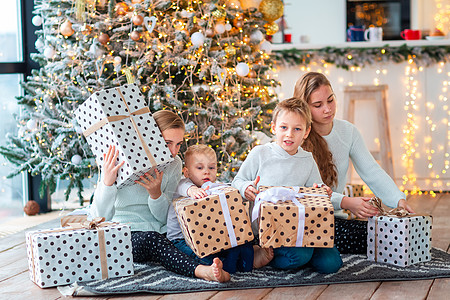 圣诞树旁边的快乐的孩子 带着这个盒子在圣诞树附近 家 家庭图片