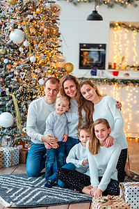 圣诞树附近幸福的一家人和现在的盒子 客厅 前夕图片