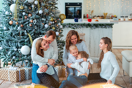 圣诞树附近幸福的一家人和现在的盒子 姐姐 魔法图片