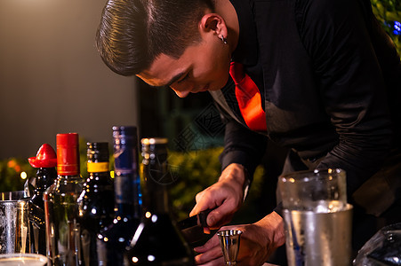 专业酒保在晚夜酒吧俱乐部柜台用冰来喝葡萄酒杯 准备新鲜果汁鸡尾酒;职业和人们的生活方式概念;户外和夜总会背景图片