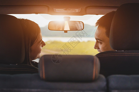 在绿色草地和山脉的野营野餐地点 亚洲夫妇在两厢车里互相看着对方的背影 人们的生活方式和交通理念 情人节和蜜月婚礼图片