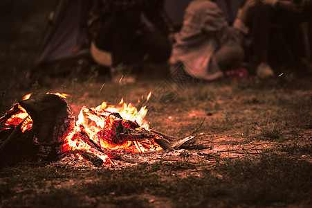 在夏夜背景下 与游客一起点燃篝火 坐在森林露营帐篷附近明亮的篝火旁 一群学生在户外生火 旅行活动和长假周末 柴 男人图片