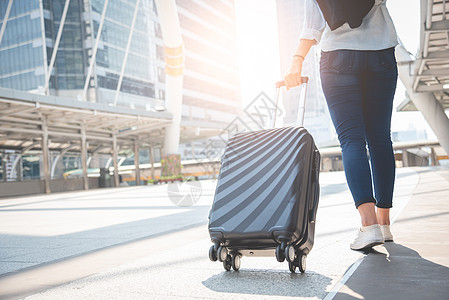 女游客在终点站提着行李走路 活动和生活方式的概念 商务人士和长假假期主题 后视图图片