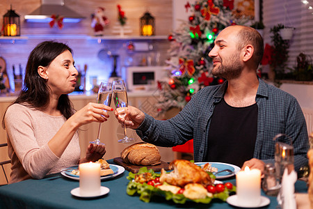 坐在餐桌旁的美酒杯全家快乐 新年 十二月 庆典 用餐图片