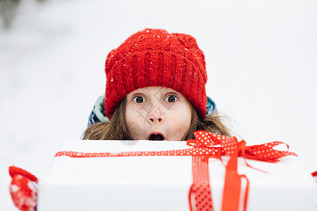 微笑的可爱女孩 6-7 岁 手拿生日礼物 在冬季背景的节日包装中 快乐的女孩在圣诞节从礼品盒里偷看的画像图片