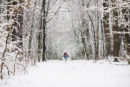 冬天 小女孩在雪树间奔跑 快乐的概念 冬天在雪地上奔跑的快乐女孩图片