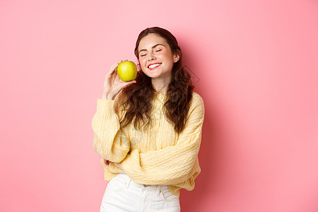 医疗保健 口腔医学和人的概念 快乐的女孩展示她洁白的牙齿 微笑和青苹果 吃着健康的食物和水果 站在粉红色的背景下 时髦 咧着嘴笑图片