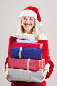 带着圣诞老人帽子的女人 拿着一大堆礼物 享受图片