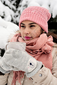 穿着温暖冬衣的漂亮女人 拿着茶杯喝热茶或雪天户外咖啡 圣诞节 围巾图片