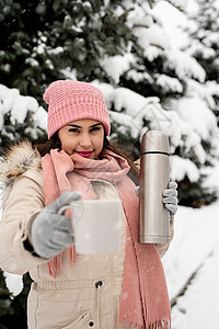 穿着温暖冬衣的漂亮女人 拿着热温水和在雪天户外喝热茶或咖啡 女士 假期图片