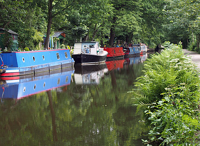 在Hebden桥的Roochdale运河上停泊的狭窄船只和驳船 周围环绕着绿树 英国 停泊处图片