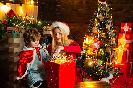 家人庆祝圣诞节 母亲带着儿子和礼物 女孩冬装圣诞老人帽子庆祝圣诞节和新年快乐 圣诞节快到了图片