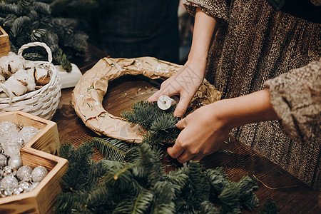创造圣诞花圈的树枝和纸板架子 是圣诞节花圈的产物 艺术 花店图片