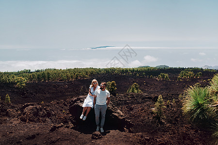 穿白衣服的一家人是穿越特内里费岛泰德火山夏季山区的游客 落基山脉上的一对年轻夫妇在云中和加那利群岛戈梅拉岛欣赏美丽的景色图片