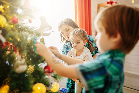 圣诞冬天快乐的家母 儿子和女儿在阳光明媚的清晨在一个装饰圣诞庆典室里 带有一棵Xmas树和礼物 孩子们 爱图片
