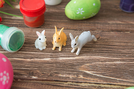 复活节鸡蛋和复活节兔子玩具 木制桌上有花朵图片