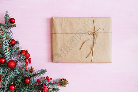 带有礼品盒 fir-tree树枝和角落中红色圣诞节装饰品的粉红木木圣诞背景 框架 从上方查看图片