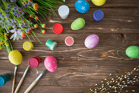 复活节概念 彩色东方鸡蛋 油漆调色盘和木制桌上的刷子 顶端视图图片
