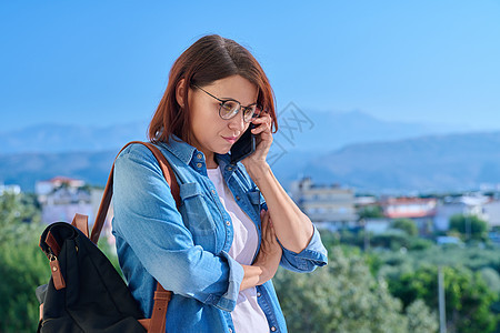 自信的中年女性在户外电话上交谈图片