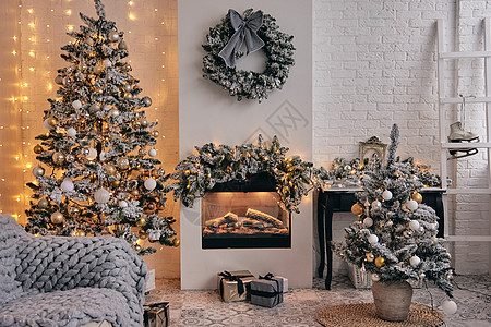 装饰舒适的房间 壁炉 银雪中的圣诞树 金色的泡泡玩具 灯和下面的礼物 美丽的holdiay DIY手工家居装饰品图片
