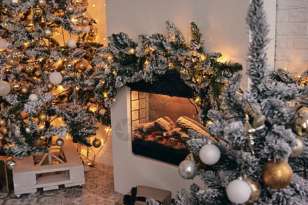 装饰舒适的房间 银雪中的圣诞树 上面有金色的泡泡玩具 灯光和礼物 美丽的手工家居装饰 照相馆的新年内饰 晚上 季节图片
