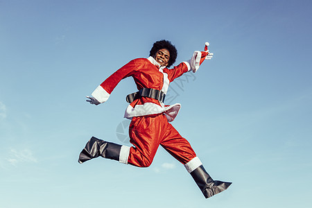 黑人Santa Claus兴奋地跳跃 对镜头微笑图片