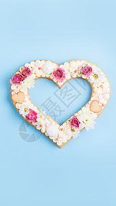 情人节那天用鲜花装饰的心形蛋糕 在假期给亲人的礼物的概念 庆典 奶油图片