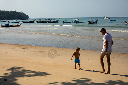 父亲和小儿子在沙滩上散步图片