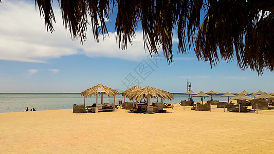 与茅草遮阳伞的海岸在沙滩 假期结束时海滩上的海景 埃及沙姆沙伊赫红海休闲的好去处图片