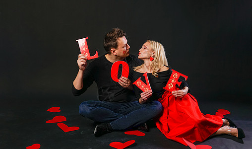 把公式家人把LOVE这个词作为幸福的象征 一颗情人的心 在地板上浪漫的心 艺术 情绪 订婚红裙女郎 赤脚情人节符号 棋盘浪漫 14 二背景