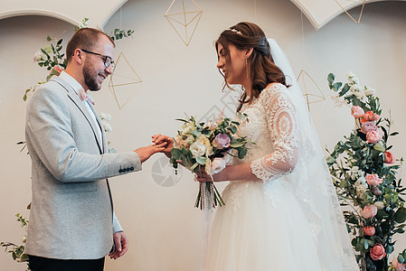 新娘和新郎交换结婚金戒指 婚姻 蕾丝 仪式图片