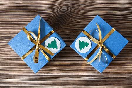 圣诞和新年在棕木木背景上印有金丝带的蓝色礼品盒 纸 圣诞节图片