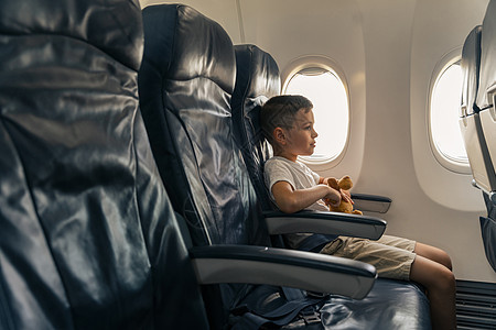 孩子 有最喜欢的玩具 坐在飞机座椅上图片