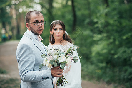 新娘和新郎的结婚照片 以灰粉色 在森林和岩石中的自然 花 美丽图片