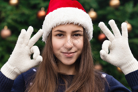 圣诞节一切都会好起来的 关闭了戴着圣诞老人帽子的女人的肖像 情绪激动 以圣诞树为背景 脸 庆典图片