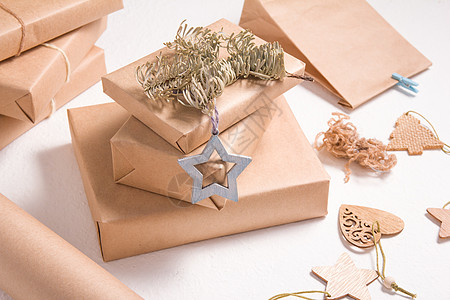 圣诞节或新年的生态友好礼品箱包装 木制圣诞玩具 用圆皮纸包着的盒子和白底面的木星 并配有树枝 工艺 横幅图片