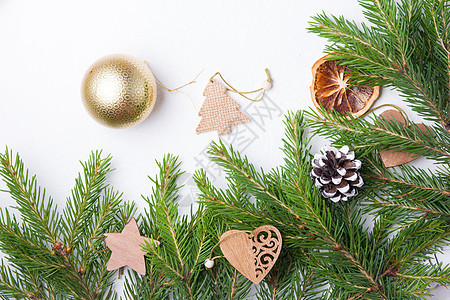 圣诞树金球和白色背景顶视图复制位置上的天然杉树枝 新鲜云杉树枝上的木制生态友好型圣诞树玩具 装饰风格 冬天图片
