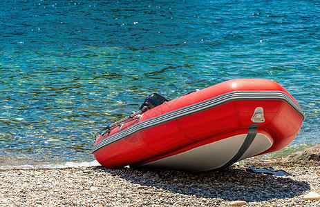 红色救援充气艇 特写 空的海上救助艇 沙滩上的充气船是红色的 灰色的地板和黑色的条纹图片